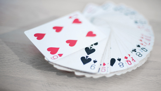 Playing cards deck isolated on a gray wooden background - red, black, and white colors